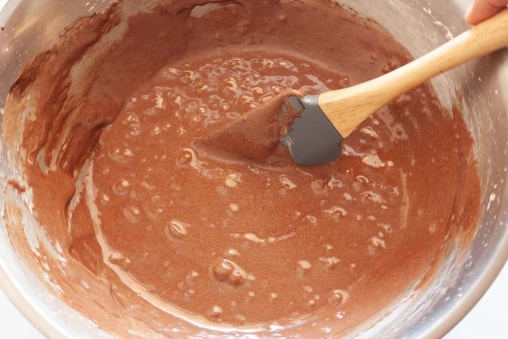 Folding the dry ingredients with the wet ingredients using a rubber spatula.