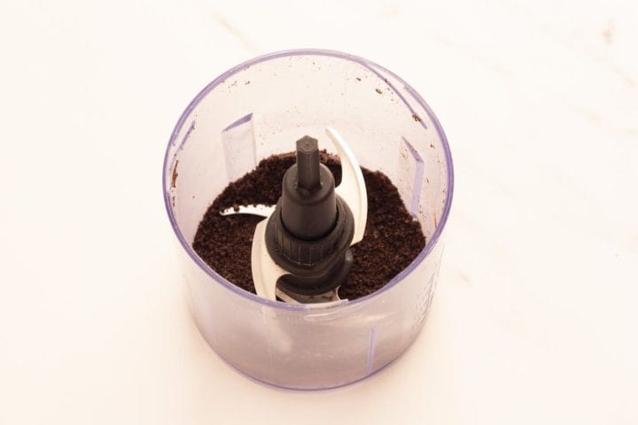 Finely ground Oreo cookies in a small food processor.
