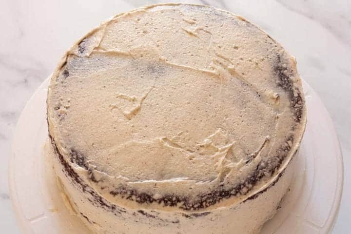 Two cake layers topped with a thin coat of cinnamon buttercream.