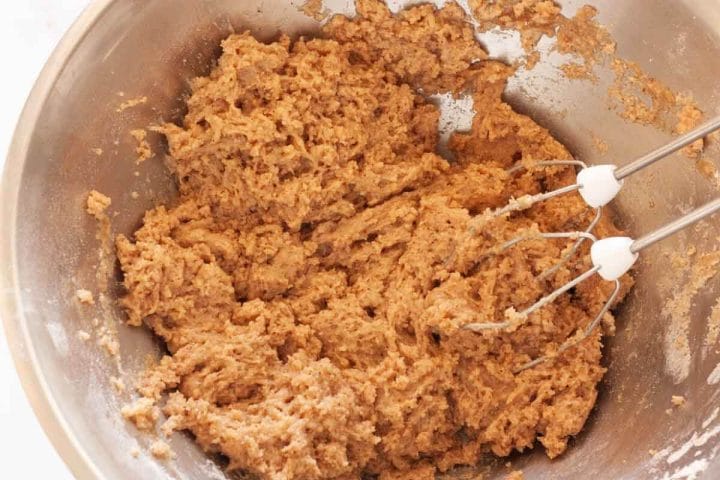 Mixing oil and buttermilk with dry ingredients with a hand mixer.