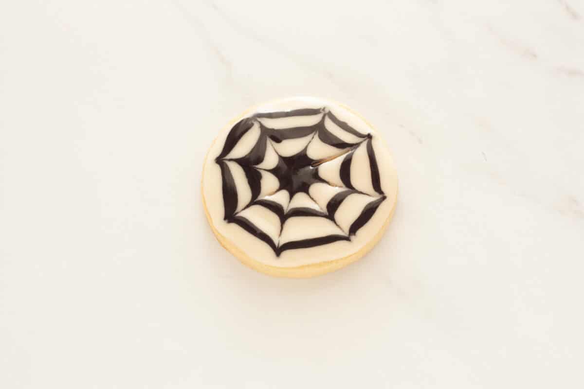 A spider web cookie with black and white glaze.