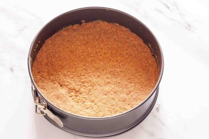 Baked cheesecake crust in a springform pan.