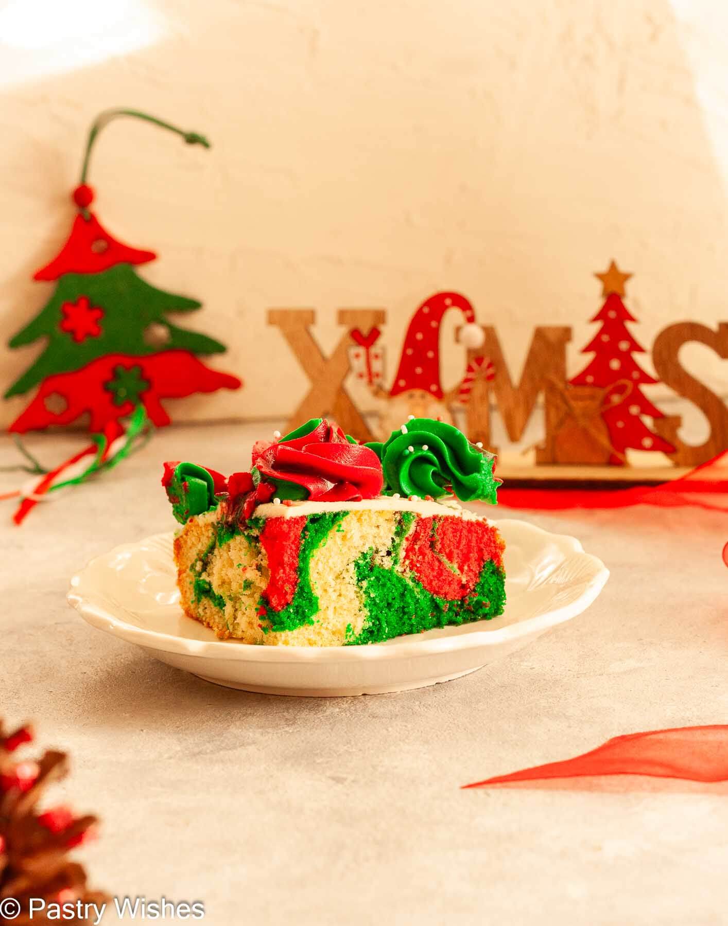 A slice of swirled Christmas sheet cake on a white plate.