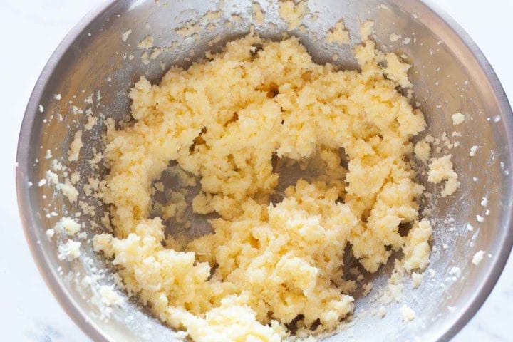 Butter mixed with sugar in a metal bowl.