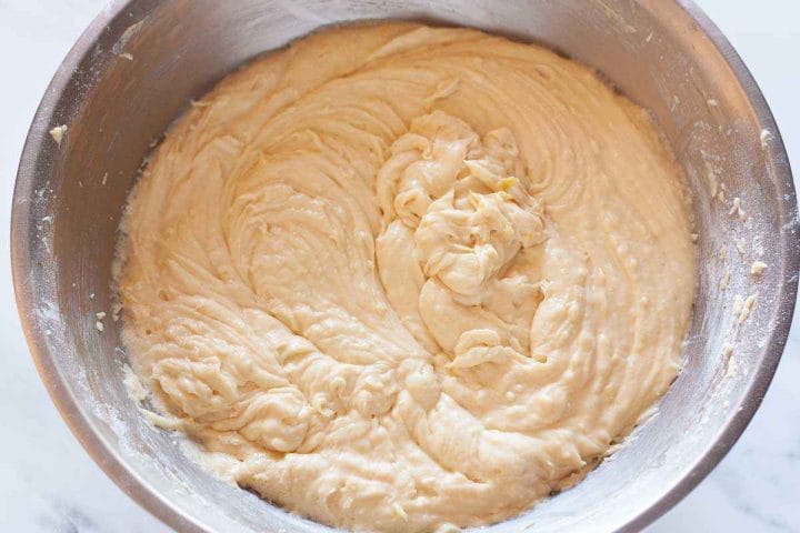 Fully combined lemon cake batter in a metal bowl.