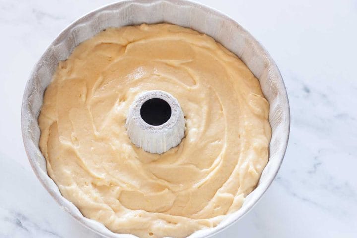 Lemon Bundt cake batter smoothed in a greased and floured Bundt pan, about two-thirds full.
