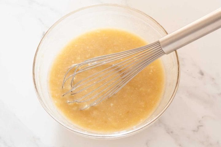 Oil, dairy free milk, sugar and vanilla extract in a glass bowl with mashed bananas.