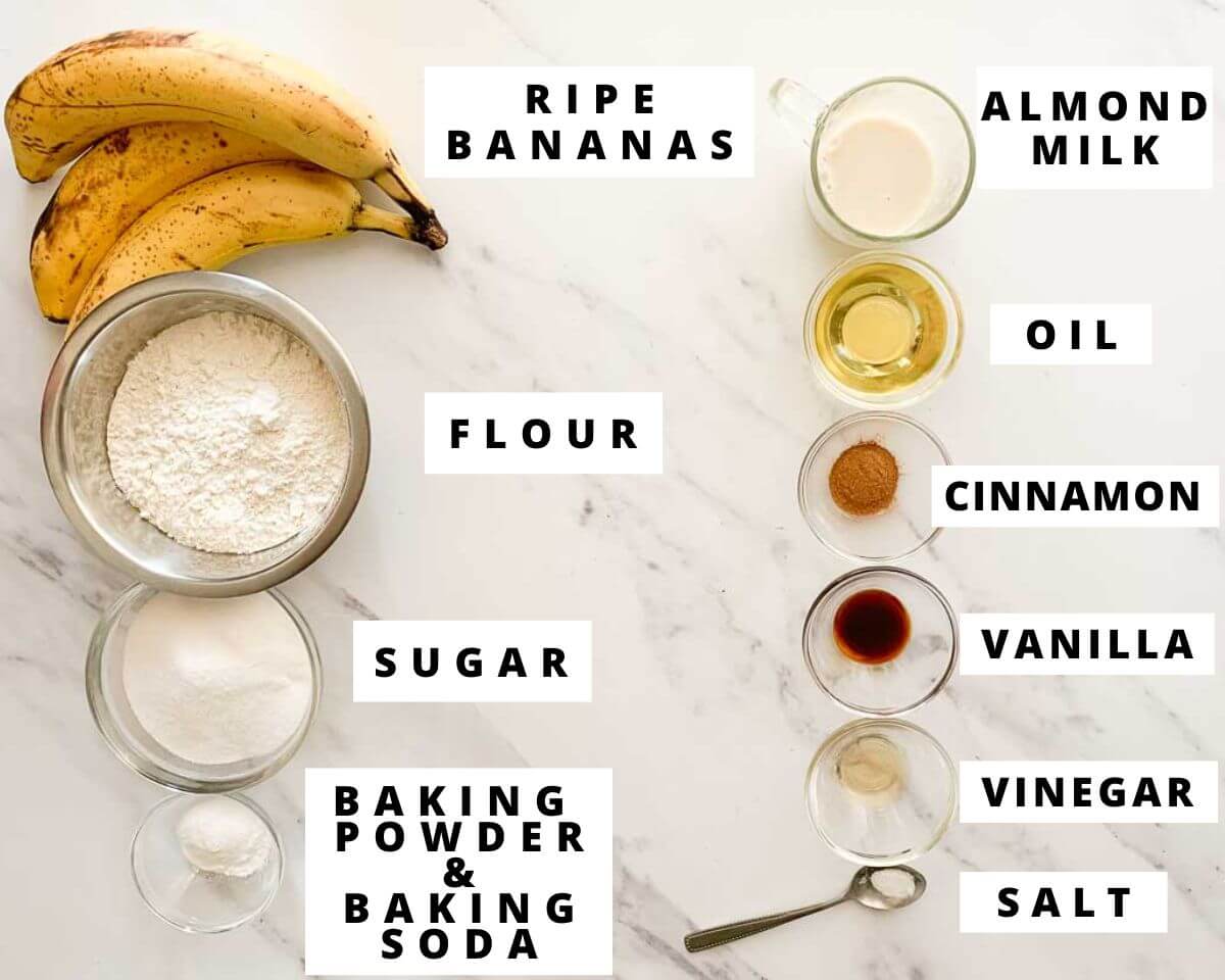 Labeled ingredients for dairy-free banana bread on a white marbled surface.