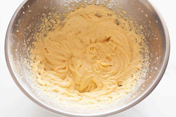 Eggs, vanilla, and lemon juice mixed into lemon raspberry loaf cake batter.