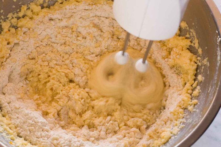Adding flour to form the koulourakia cookie dough.