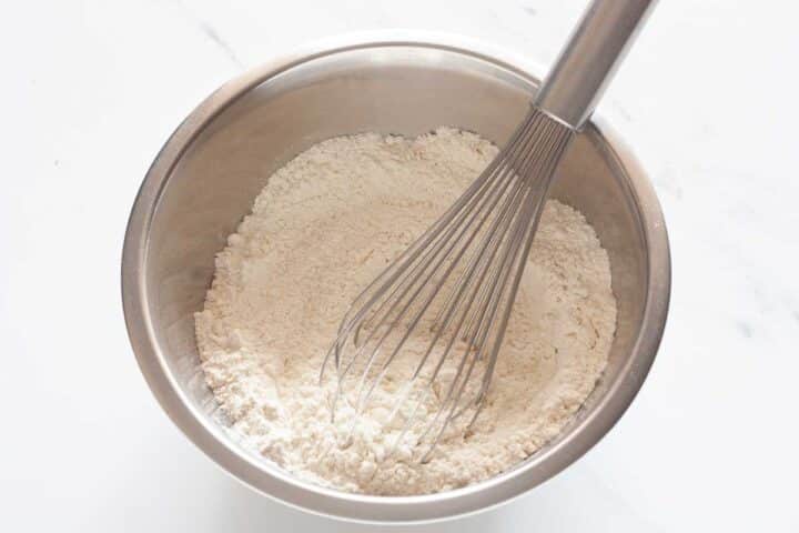 Flour, baking powder, baking soda, and salt whisked together in a bowl.