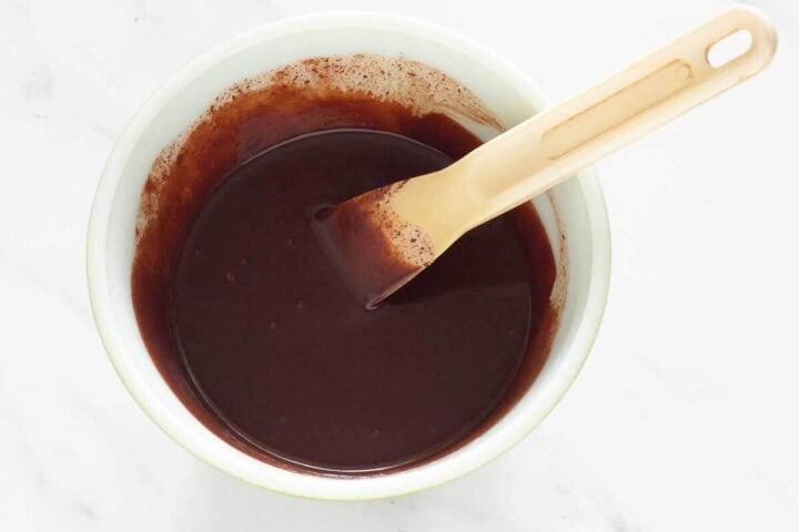 Blending hot cream into chocolate ganache until fully combined, step 3.