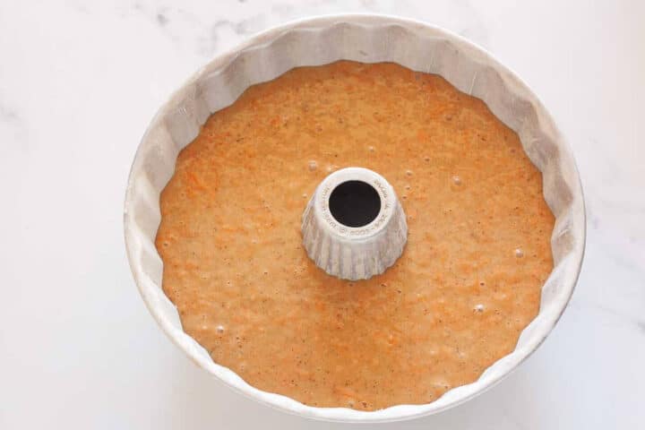 Carrot cake batter poured into a prepared Bundt pan.