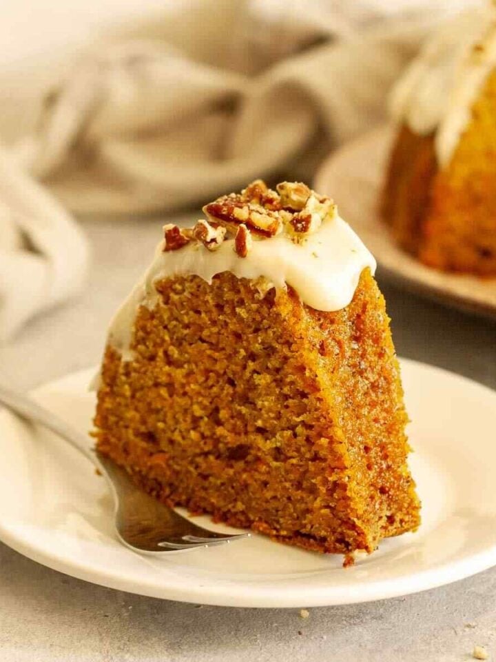 Carrot Bundt cake with cream cheese glaze served on a plate.