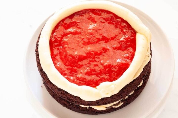 Chocolate cake with strawberry filling and buttercream, topped with a second chocolate cake layer.