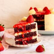 Slice of chocolate cake with strawberry filling and vanilla buttercream frosting.