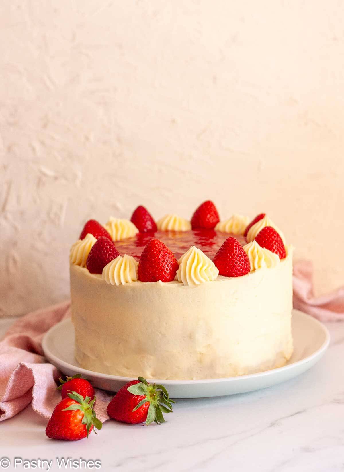 Chocolate cake with strawberry filling frosted in vanilla buttercream and topped with fresh strawberries.