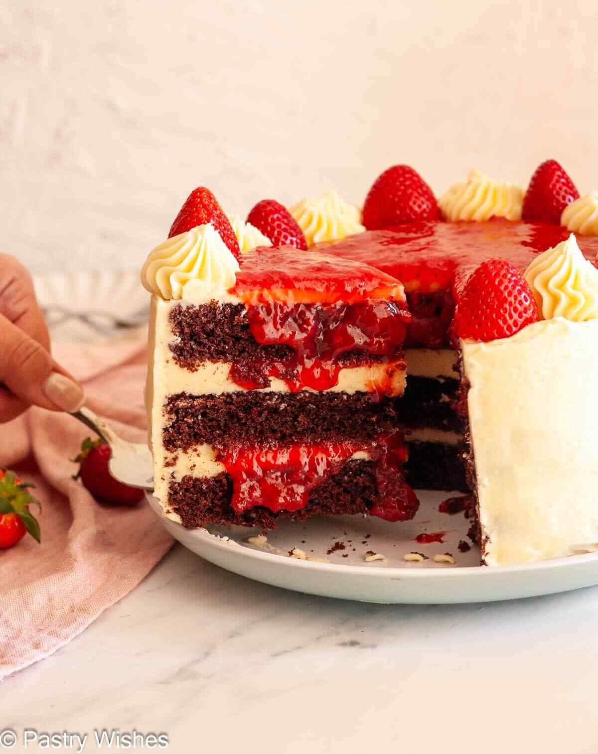 Chocolate cake with strawberry filling showing layers of buttercream and fresh strawberries.