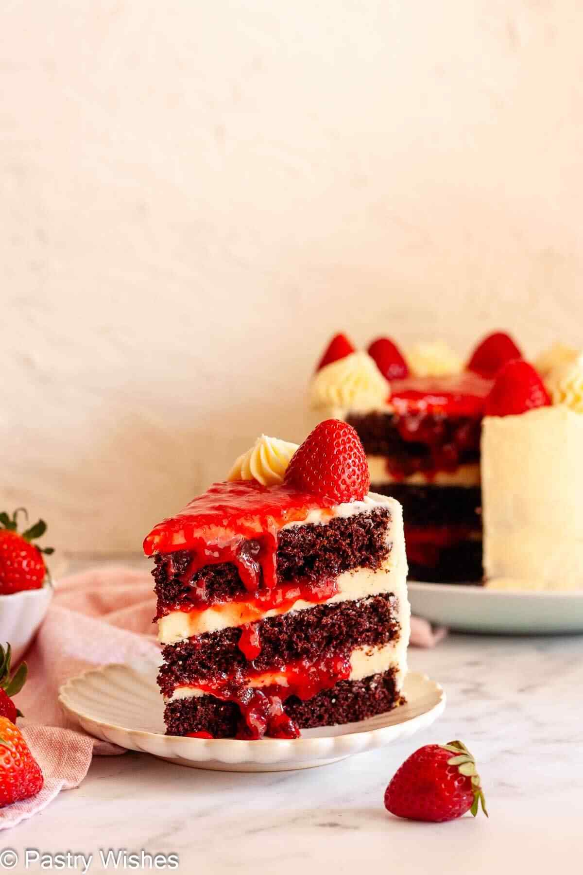 Chocolate cake with strawberry filling showing layers of buttercream and toped with fresh strawberries.