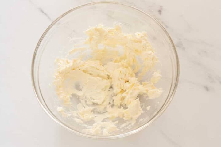 Cream cheese being beaten until smooth for glaze.