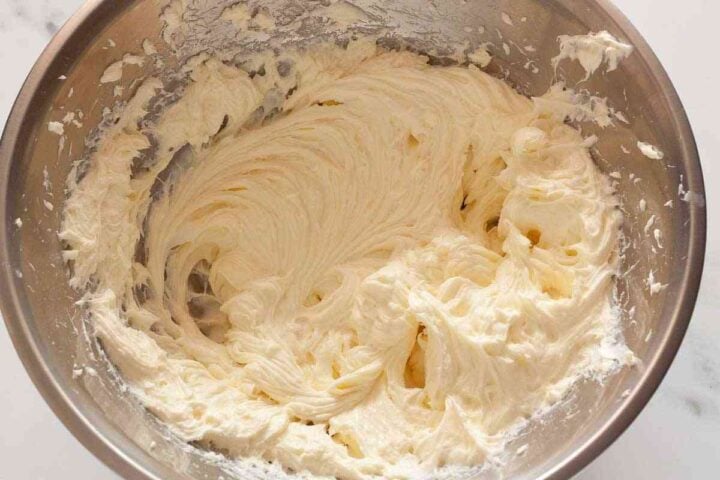 Cream cheese and sugar mixed until smooth for cheesecake filling.