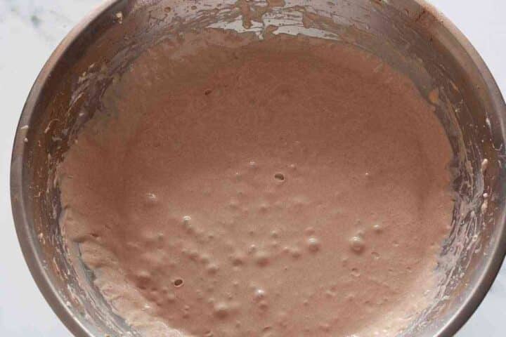 Eggs added and mixed into chocolate cheesecake batter.