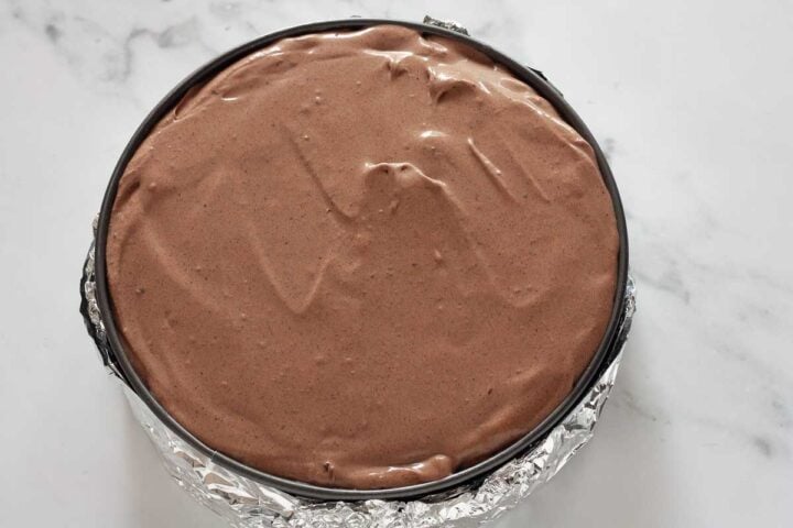 Cheesecake batter poured over prepared crust in pan.