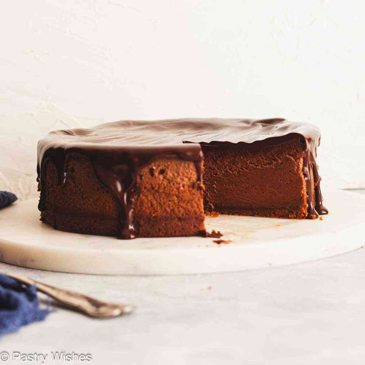 Sliced chocolate ganache cheesecake with glossy ganache topping.