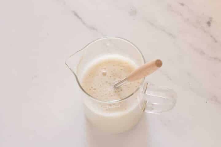 Homemade vegan buttermilk made with almond milk and vinegar in a measuring jug.