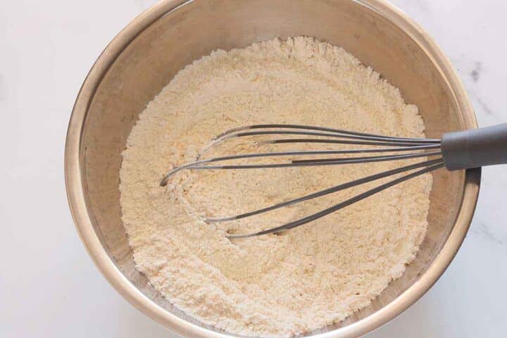 Dry ingredients whisked together in a bowl for eggless lemon cake.