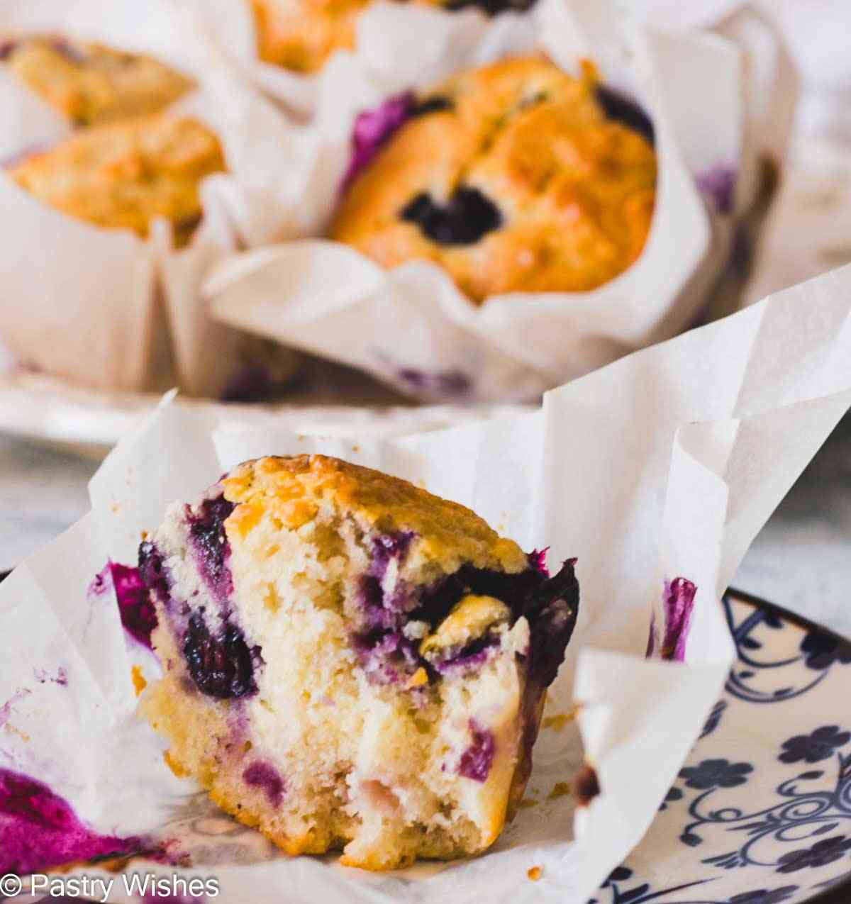 Greek yogurt blueberry muffin cut in half showing the soft fluffy crumb and juicy blueberries.