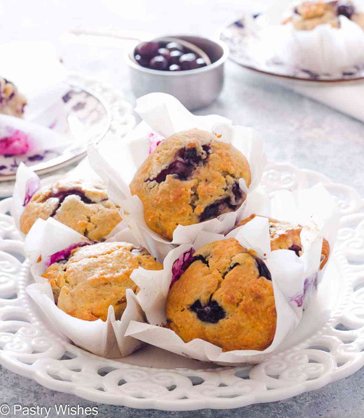Greek yogurt blueberry muffins on a white serving plate.
