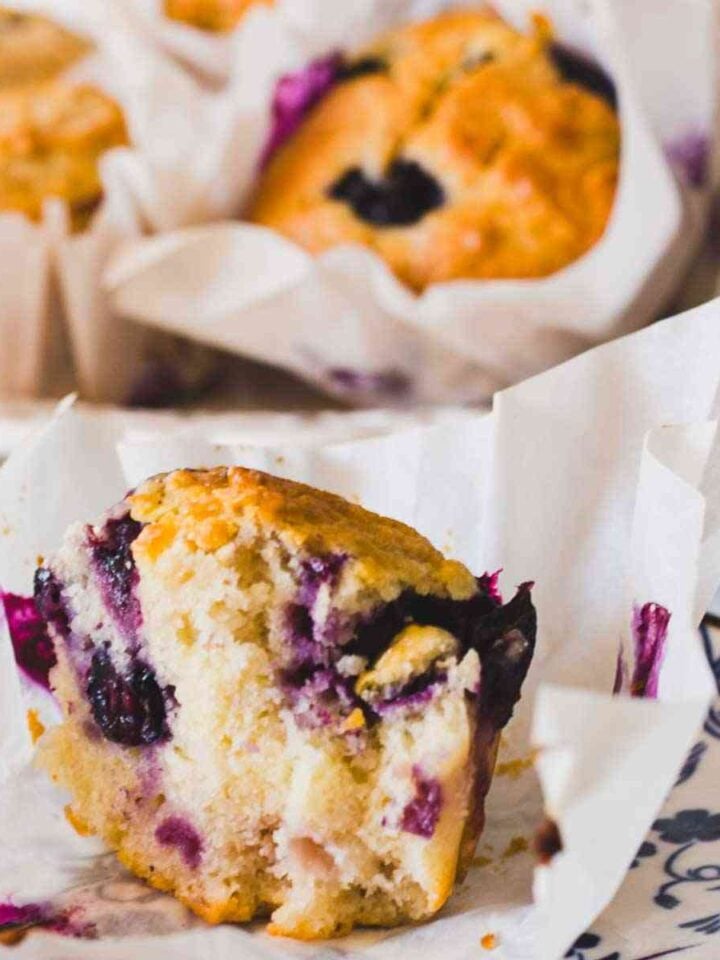 Greek yogurt blueberry muffin cut open showing juicy blueberries and fluffy texture.