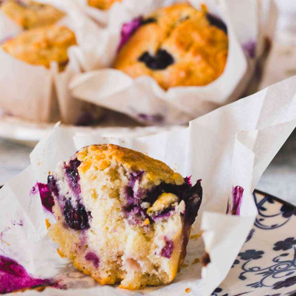 Greek yogurt blueberry muffin cut open showing juicy blueberries and fluffy texture.