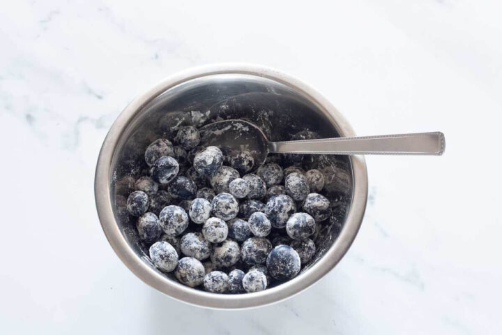 Blueberries coated in flour in a small bowl.