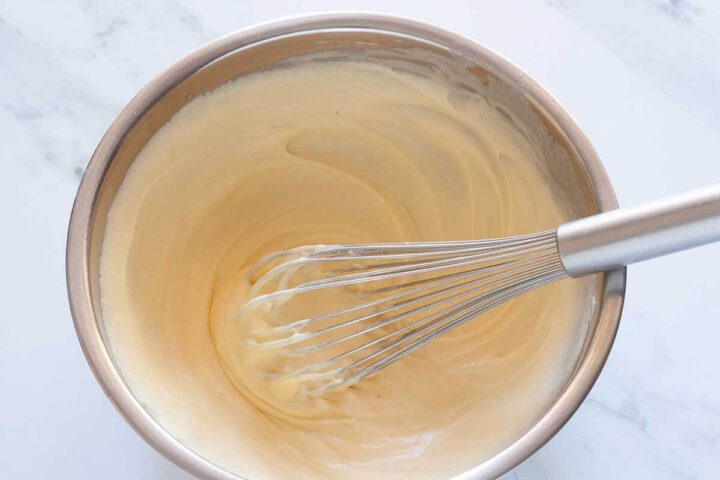 Eggs whisked into the wet ingredients for Greek yogurt blueberry muffins.