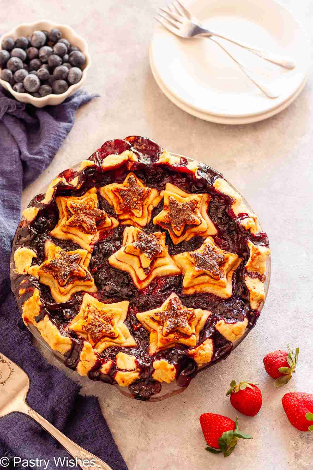 Homemade strawberry blueberry pie with star crust baked until golden brown.