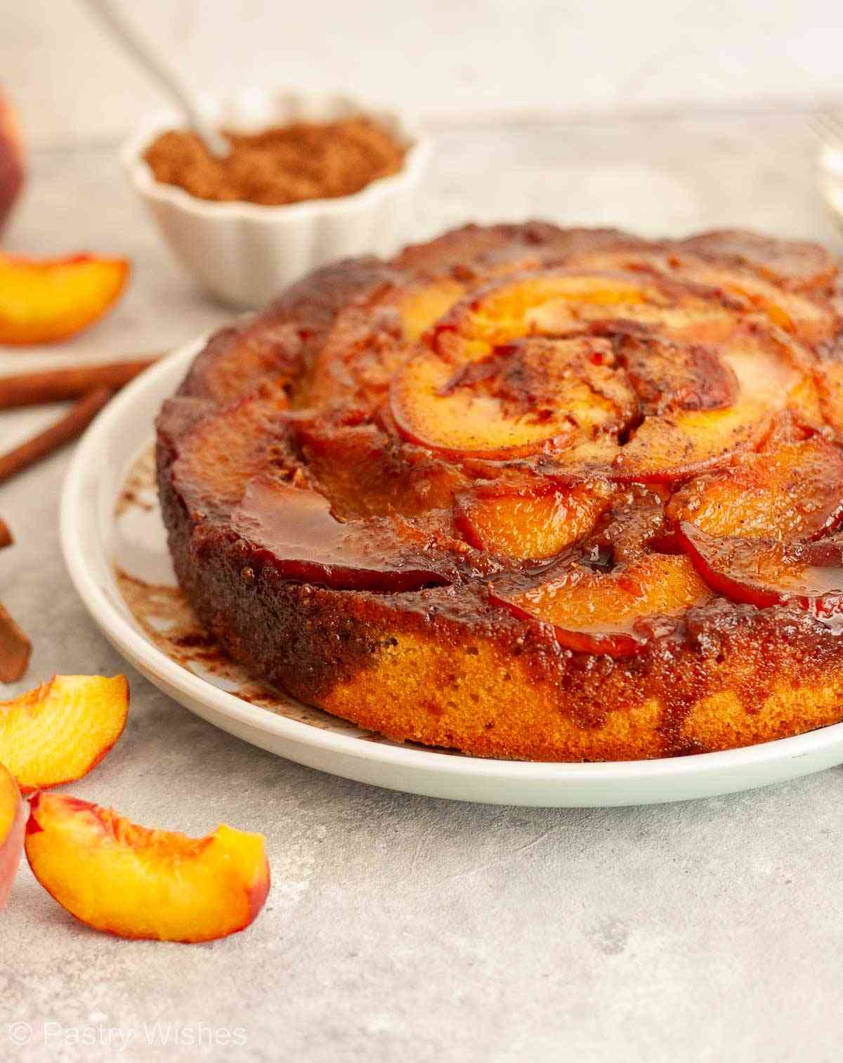 Caramel peach upside-down cake topped with caramelized peach slices and cinnamon.
