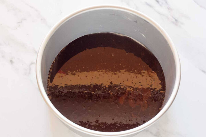 Bourbon caramel spread evenly over the bottom of a round cake pan.