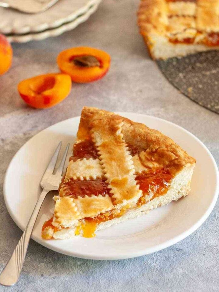 lice of Greek pasta flora with apricot jam on a white plate.