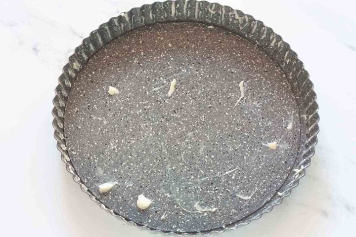 Buttered 28 cm tart pan for making Greek pasta flora.