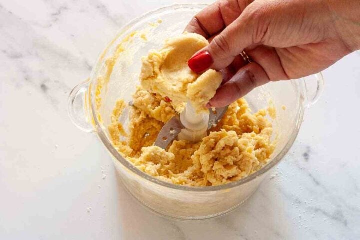 Pasta flora dough clumping together in a food processor.