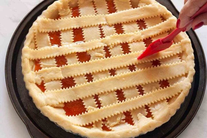 Pasta flora lattice strips brushed with egg wash before baking.