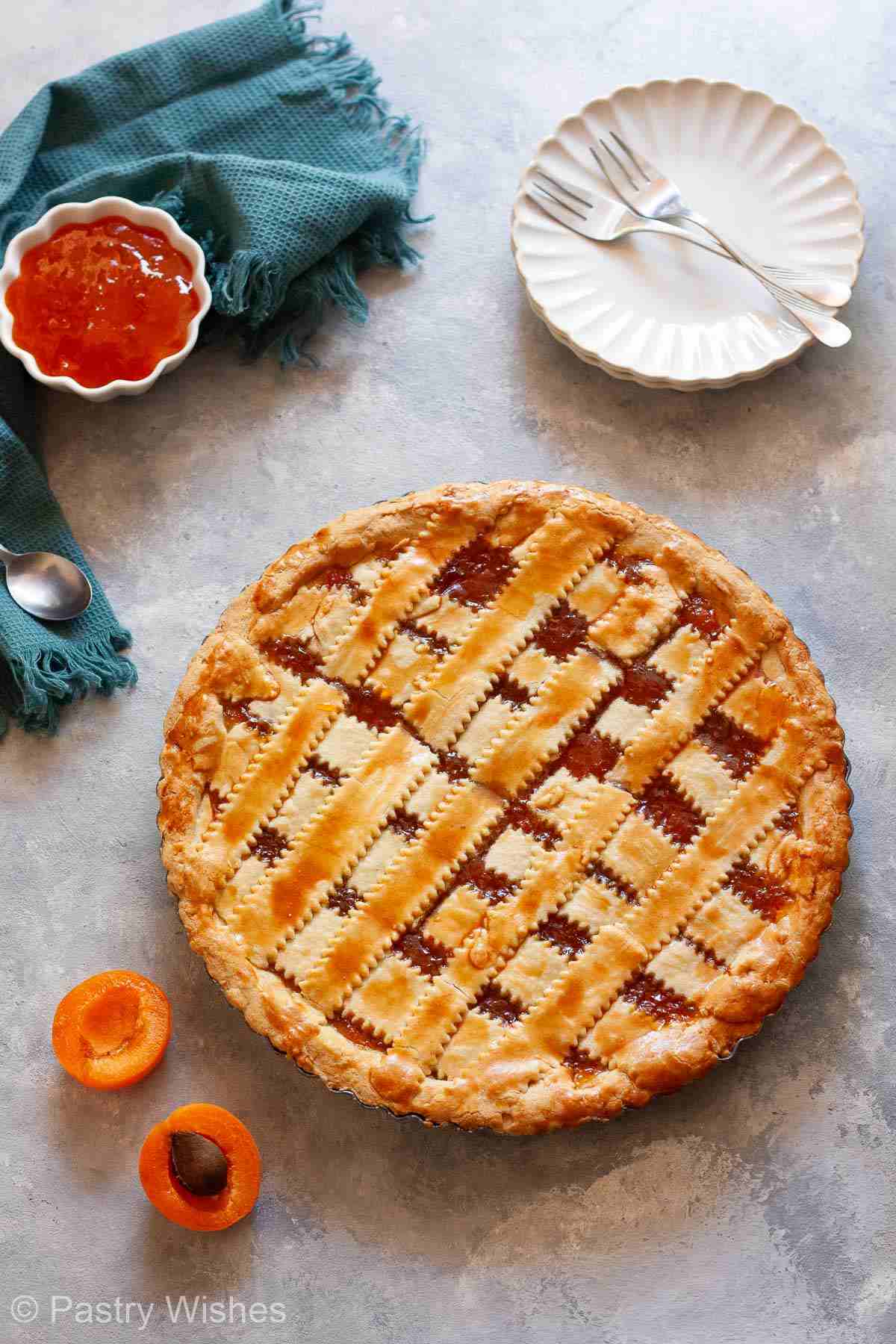 Baked Greek jam tart with golden crisscross topping and apricot filling.