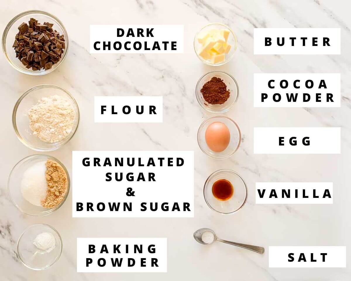 Labeled ingredients for brownie crinkle cookies, including dark chocolate, butter, flour, sugars, cocoa powder, egg, vanilla, baking powder, and salt.