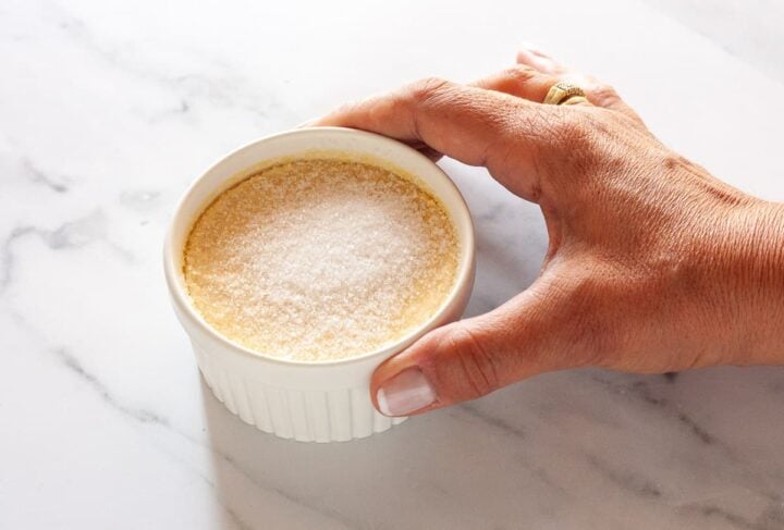Chilled crème brûlée topped with a layer of granulated sugar before torching.
